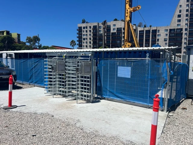 Full-height turnstiles integrated with temporary site fencing.